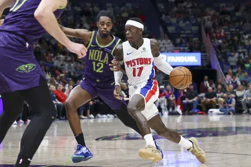 Detroit Pistons guard Dennis Schroeder (17) tries to drive past New Orleans Pelicans guard Antonio Reeves (12) in the second half of an NBA basketball game in New Orleans, Monday, March 17, 2025. (AP Photo/Peter Forest)