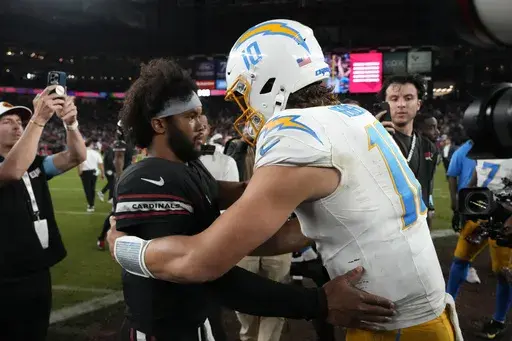 Arizona Cardinals quarterback Kyler Murray, left, talks with Los Angeles Chargers quarterback Justin Herbert (10) after an NFL football game, Monday, Oct. 21, 2024, in Glendale Ariz. (AP Photo/Matt York)