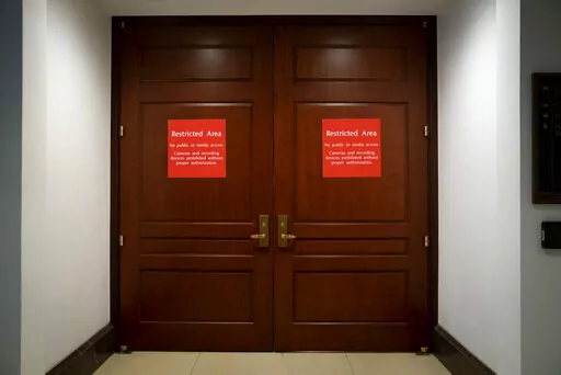 Bright red signs alert non-authorized personnel at the entrance to the House SCIF, the Sensitive Compartmented Information Facility, located three levels beneath the Capitol where witnesses and lawmakers hold closed interviews in the impeachment inquiry on President Donald Trump's efforts to press Ukraine to investigate his political rivals, in Washington, Nov. 6, 2019. When members of Congress want to peruse classified materials, they descend deep into the basement of the Capitol to a sensitive