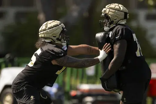 New Orleans Saints offensive tackle Taliese Fuaga, left works on a drill during NFL football training camp, Friday, July 26, 2024, in Irvine, Calif. (AP Photo/Kyusung Gong)