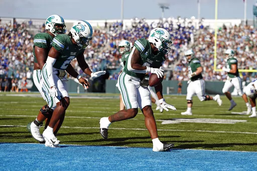 Tulane running back Shaadie Clayton (0) celebrates with wide receiver Duece Watts (2) after scoring a touchdown during the first half of an NCAA college football game against Memphis in New Orleans, Saturday, Oct. 22, 2022. (AP Photo/Tyler Kaufman)