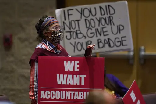 Parents and family members hold signs at a meeting of the Board of Trustees of the Uvalde Consolidated Independent School District where Uvalde School District Police Chief Pete Arredondo was dismissed, Wednesday, Aug. 24, 2022, in Uvalde, Texas. (AP Photo/Eric Gay)