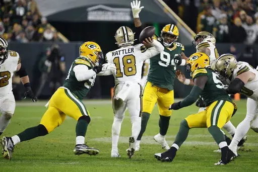 New Orleans Saints quarterback Spencer Rattler (18) passes under pressure during the second half of an NFL football game against the Green Bay Packers, Monday, Dec. 23, 2024, in Green Bay, Wis. (AP Photo/Mike Roemer)