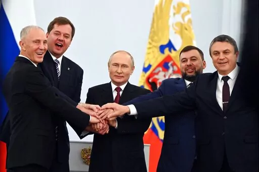 From left, Moscow-appointed head of Kherson Region Vladimir Saldo, Moscow-appointed head of Zaporizhzhia region Yevgeny Balitsky, Russian President Vladimir Putin, center, Denis Pushilin, leader of self-proclaimed of the Donetsk People's Republic and Leonid Pasechnik, leader of self-proclaimed Luhansk People's Republic pose for a photo during a ceremony to sign the treaties for four regions of Ukraine to join Russia, at the Kremlin in Moscow, on Sept. 30, 2022. (Grigory Sysoyev, Sputnik, Kremlin