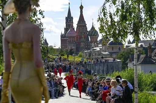 A model displays the collection by Russian designer Slava Zaitsev during the opening of the Fashion Week in at Zaryadye Park with the Spasskaya Tower and St. Basil's Cathedral in the background near Red Square in Moscow, Russia, on June 20, 2022. Luxury spending is growing faster than ever, fueled by pent-up pandemic demand and shifting demographics as younger, more diverse consumers buy into tiny handbag and post-streetwear trends, according to a new study by Bain consultancy released on Tuesda