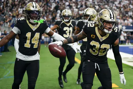New Orleans Saints safety Tyrann Mathieu (32) reacts with teammates, including Kool-Aid McKinstry (14) and Jordan Howden (31) after intercepting a pass by Dallas Cowboys quarterback Dak Prescott during the second half of an NFL football game, Sunday, Sept. 15, 2024, in Arlington, Texas. (AP Photo/Jeffrey McWhorter)