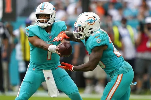 Miami Dolphins quarterback Tua Tagovailoa (1) hands the ball to running back Duke Johnson (28) during the first half of an NFL football game against the New York Jets, Sunday, Dec. 19, 2021, in Miami Gardens, Fla. (AP Photo/Lynne Sladky)