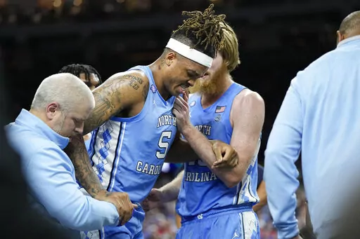 North Carolina forward Armando Bacot is helped off the court during the second half of a college basketball game against Duke in the semifinal round of the Men's Final Four NCAA tournament, Saturday, April 2, 2022, in New Orleans. (AP Photo/David J. Phillip)