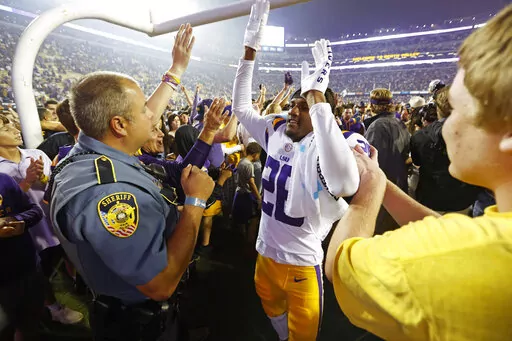 LSU cornerback Damarius McGhee (26) celebrates with fans who stormed the field after an NCAA college football game against Alabama in Baton Rouge, La., Saturday, Nov. 5, 2022. LSU won 32-31 in overtime. (AP Photo/Tyler Kaufman)
