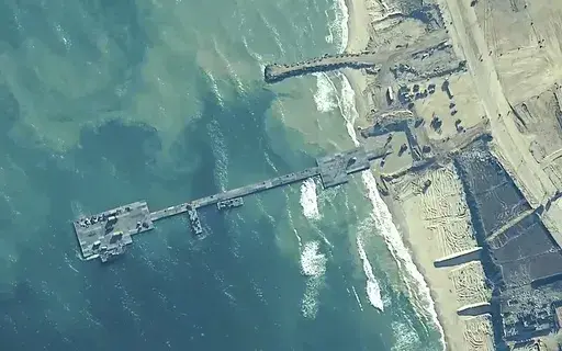 The image provided by U.S, Central Command, shows U.S. Army soldiers assigned to the 7th Transportation Brigade (Expeditionary), U.S. Navy sailors assigned to Amphibious Construction Battalion 1, and Israel Defense Forces placing the Trident Pier on the coast of Gaza Strip on May 16, 2024. The U.S. military-built pier to carry humanitarian aid to Gaza is being dismantled and brought home, ending a mission that has been fraught with weather and security problems. (U.S. Central Command via AP)