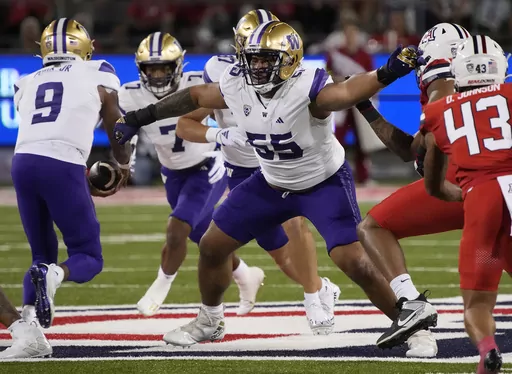 Washington offensive lineman Troy Fautanu (55) blocks for running back Dillon Johnson (7) who takes a handoff from quarterback Michael Penix Jr. (9) in the first half during an NCAA college football game against Arizona Sept. 30, 2023, in Tucson, Ariz. Fautanu and the Huskies' offensive line paved the way for No. 2 Washington to make the College Football Playoff. They are scheduled to face No. 3 Texas in the Sugar Bowl, Monday, Jan. 1, 2024. (AP Photo/Rick Scuteri)