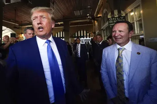 Former President Donald Trump, left, and then Louisiana Attorney General Jeff Landry visit Café du Monde in New Orleans, July 25, 2023. (AP Photo/Gerald Herbert, File)