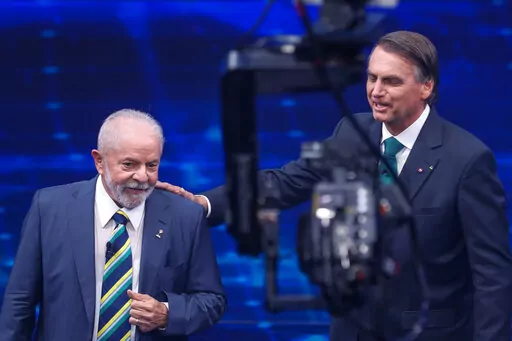 Brazil's former President Luiz Inacio Lula da Silva, who is running for office again, left, faces Jair Bolsonaro in a presidential debate at Bandeirantes Television in Sao Paulo, Brazil, Sunday, Oct. 16, 2022. The presidential runoff election is set for Oct. 30. (AP Photo/Marcelo Chello)