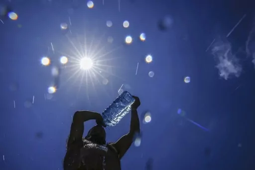 A man pours cold water onto his head to cool off on a sweltering hot day in the Mediterranean Sea in Beirut, Lebanon, Sunday, July 16, 2023. In the past 30 days, nearly 5,000 heat and rainfall records have been broken or tied in the United States and more than 10,000 records set globally, according to the National Oceanic and Atmospheric Administration. Since 2000, the U.S. is setting about twice as many heat records as cold. (AP Photo/Hassan Ammar, File)
