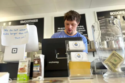 Patrick Chapman, 27, prepares for customers Thursday, March 2, 2023, at The Golden Scoop, an Overland Park, Kan., ice cream and coffee shop that employs workers with developmental disabilities, paying them more than minimum wage. But some disabled workers employed at so-called sheltered workshops are earning far less than minimum wage, an issue that has captured the attention of lawmakers in the state. Disability rights advocates say the practice is discriminatory and more than a dozen states ha