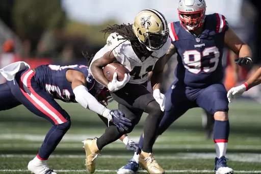 New Orleans Saints running back Alvin Kamara (41) runs under pressure from New England Patriots safety Kyle Dugger, left, and defensive end Lawrence Guy Sr., right, during the second half of an NFL football game, Sunday, Oct. 8, 2023, in Foxborough, Mass. (AP Photo/Charles Krupa)