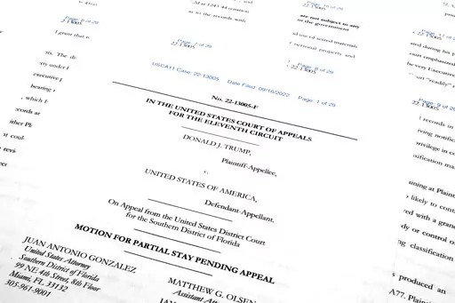 Pages from the Justice Department's motion to the 11th Circuit U.S. Court of Appeals in Atlanta are photographed Friday, Sept. 16, 2022. The Justice Department asked the federal appeals court to lift a judge's order that temporarily barred it from reviewing a batch of classified documents seized during an FBI search of former President Donald Trump's Florida home last month. (AP Photo/Jon Elswick)