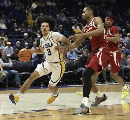 LSU guard Curtis Givens III (3) drives down the court as Arkansas forward Jonas Aidoo (9) defends in an NCAA college basketball game at the LSU PMAC in Baton Rouge, La., Tuesday, Jan. 14, 2025. (Hilary Scheinuk/The Advocate via AP)