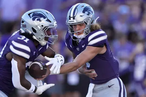 Kansas State quarterback Avery Johnson, right, hands off to running back DJ Giddens (31) during practice before an NCAA college football game against UT Martin Saturday, Aug. 31, 2024, in Manhattan, Kan. (AP Photo/Charlie Riedel)