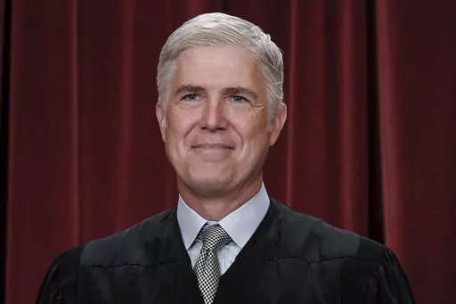 Associate Justice Neil Gorsuch joins other members of the Supreme Court as they pose for a new group portrait, at the Supreme Court building in Washington, Friday, Oct. 7, 2022. Gorsuch called emergency measures taken during the COVID-19 crisis that killed more than 1 million Americans perhaps “the greatest intrusions on civil liberties in the peacetime history of this country.” The 55-year-old conservative justice pointed to orders closing schools, restricting church services, mandating vac