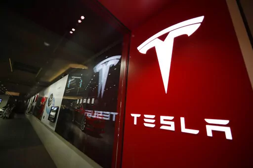 A sign bearing the company logo outside a Tesla store in Cherry Creek Mall in Denver is seen here on Feb. 9, 2019. Tesla is recalling nearly 363,000 vehicles with its “Full Self-Driving” system to fix problems with the way it behaves around intersections and following posted speed limits, the National Highway Traffic Safety Administration announced Thursday, Feb. 16, 2023. (AP Photo/David Zalubowski, File)