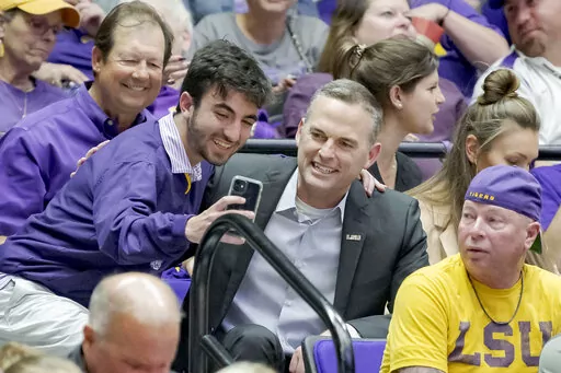 Former Murray State head coach Matt McMahon, center, poses for a photo after being hired as the men's basketball head coach for LSU during the second half of a women's college basketball game between LSU and Ohio State in the second round of the NCAA tournament, Monday, March 21, 2022, in Baton Rouge, La. (AP Photo/Matthew Hinton)