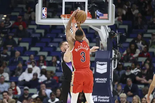 New Orleans Pelicans guard CJ McCollum (3) shoots a 3-pointer over Utah Jazz guard Svi Mykhailiuk in the first half of an NBA basketball game in New Orleans, Monday, Jan. 20, 2025. (AP Photo/Peter Forest)
