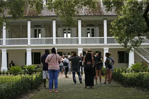 Visitors walk outside the main plantation house at the Whitney Plantation in Edgard, La., July 14, 2017. (AP Photo/Gerald Herbert, File)