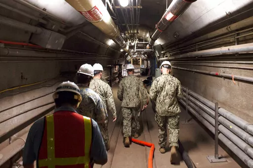 In this Dec. 23, 2021, photo provided by the U.S. Navy, Rear Adm. John Korka, Commander, Naval Facilities Engineering Systems Command (NAVFAC), and Chief of Civil Engineers, leads Navy and civilian water quality recovery experts through the tunnels of the Red Hill Bulk Fuel Storage Facility, near Pearl Harbor, Hawaii. Native Hawaiians who revere water in all its forms as the embodiment of a Hawaiian god say the Navy's acknowledgement that jet fuel leaked into Pearl Harbor's tap water has deepene