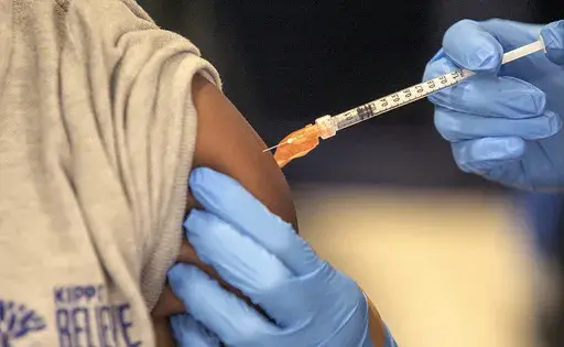 Medical personnel vaccinate students at a school in New Orleans on Jan. 25, 2022. (AP Photo/Ted Jackson, File)