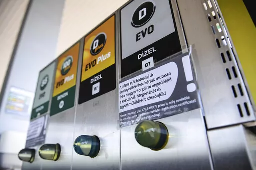 An sign at a petrol station gives information on the discount of fuel, in Budapest, Hungary, Sunday, June 12, 2022. Hungary has placed price caps on fuel and some food and imposed special taxes on industries as the government tries to ease an economic downturn and the highest inflation in nearly 25 years. (AP Photo/Anna Szilagyi)
