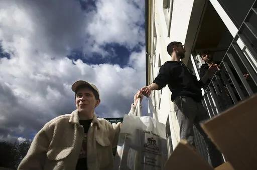 From left, Danya, 21, Gabriel, 21 and Borden, 17 all refugees from Odesa, Ukraine help to deliver bags with food to needy people during preparations for the celebration of Jewish Passover at the Chabad Jewish Education Center in Berlin, Germany, Thursday, April 7, 2022. Rabbis and Jewish organizations are working round the clock within Ukraine, Eastern Europe and other parts of Europe to make sure that Jews who remain in Ukraine and refugees who have fled as far away as Israel are able to celebr