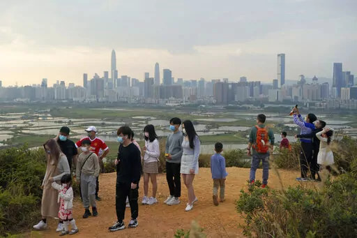 People visit the border of Hong Kong, with the skyline of China's Shenzhen in the background, in Hong Kong Feb. 13, 2021. Hong Kong will start to reopen its border with mainland China on Sunday, Jan. 8, 2023, allowing tens of thousands of people to travel between both sides each day under a quarantine-free arrangement, the city's leader said Thursday, Jan. 5. (AP Photo/Kin Cheung, File)
