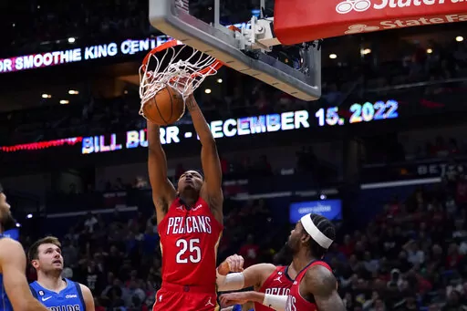 New Orleans Pelicans guard Trey Murphy III (25) slam dunks over Dallas Mavericks guard Luka Doncic, left, in the second half of an NBA basketball game in New Orleans, Tuesday, Oct. 25, 2022. The Pelicans won 113-111. (AP Photo/Gerald Herbert)