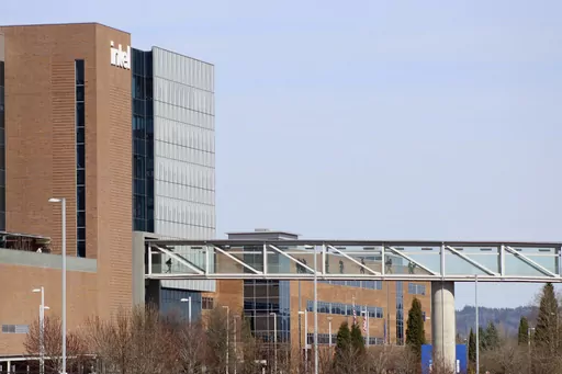 Workers walk on a skybridge to and from a large Intel facility in Hillsboro, Ore., on March 17, 2023. Intel, which produces semiconductor chips, is Oregon's biggest corporate employer. Lawmakers are considering a bill that would allow the governor to expand urban growth boundaries for semiconductor-related industries. (AP Photo/Andrew Selsky)