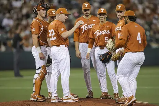 Texas head coach Jim Schlossnagle (22) delivers the ball to relief pitcher Jason Flores (4) during an NCAA baseball game against Texas St. on April 1, 2025, in Austin, Texas. (AP Photo/Stephen Spillman, file)