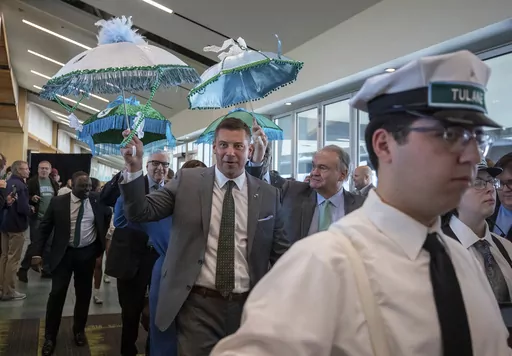 Jon Sumrall, center, the new head NCAA college football coach at Tulane, walks into his introduction ceremony with Tulane President Michael Fitts, center right, and others before being introduced by athletic director David Harris (not shown) at Yulman Stadium in New Orleans, Monday, Dec. 11, 2023. (David Grunfeld/The Times-Picayune/The New Orleans Advocate via AP)