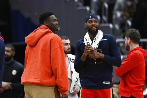 Injured New Orleans Pelicans forward Zion Williamson, left, talks with forward Naji Marshall, second from right, during a timeout in the second half of an NBA basketball game against the Washington Wizards, Monday, Jan. 9, 2023, in Washington. (AP Photo/Terrance Williams)