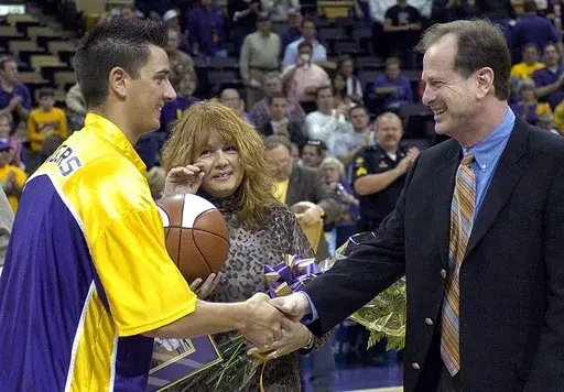 LSU senior Josh Maravich, left, shakes hands with coach John Brady as his mother, Jackie Maravich, center, watches during Senior Day events before LSU's NCAA college basketball game against Vanderbilt on March 5, 2005, at the Pete Maravich Assembly Center in Baton Rouge, La. Maravich, son of Pete Maravich, has died at age 42, the university announced Saturday, June 8, 2024. Josh Maravich was found unresponsive at home Friday, the LSU statement said. (AP Photo/Bill Feig, File)