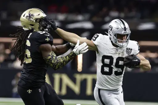 Las Vegas Raiders tight end Brock Bowers (89) runs from New Orleans Saints linebacker Demario Davis (56) after catching a pass during the second half of an NFL football game, Sunday, Dec. 29, 2024, in New Orleans. (AP Photo/Butch Dill)