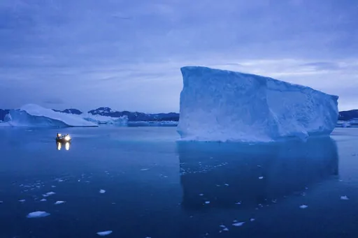 A boat navigates at night next to large icebergs in eastern Greenland on Aug. 15, 2019. Zombie ice from the massive Greenland ice sheet will eventually raise global sea level by at least 10 inches (27 centimeters) on its own, according to a study released Monday, Aug. 29, 2022.  Zombie or doomed ice is still attached to thicker areas of ice, but it’s no longer getting fed by those larger glaciers.  (AP Photo/Felipe Dana, File)