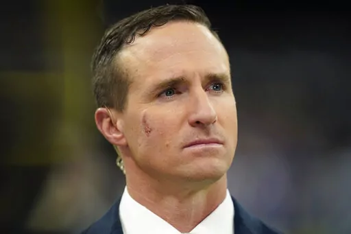 Former New Orleans Saints quarterback Drew Brees, now a TV analyst, talks on the field before an NFL football game against the Buffalo Bills in New Orleans, on Nov. 25, 2021. Brees is officially done at NBC Sports after one year. NBC Sports president Pete Bevacqua said in a phone interview with the Associated Press that Brees will not be a part of the network’s NFL and Notre Dame coverage this year.(AP Photo/Derick Hingle, File)