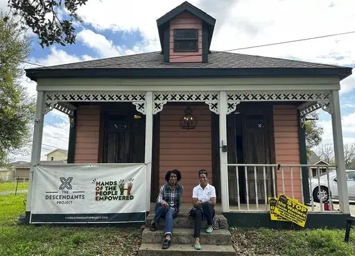 Twin sisters Jo and Joy Banner pose on the porch of their place of business, Fee-Fo-Lay Café, March 13, 2024, Wallace, La. (AP Photo/Stephen Smith, File)