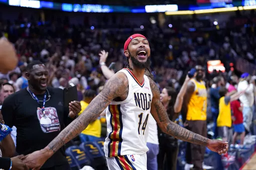 New Orleans Pelicans forward Brandon Ingram (14) celebrates after hugging his father Donald Ingram, left, after defeating the Los Angeles Lakers in an NBA basketball game in New Orleans, Sunday, March 27, 2022. The Pelicans won 116-108. (AP Photo/Gerald Herbert)