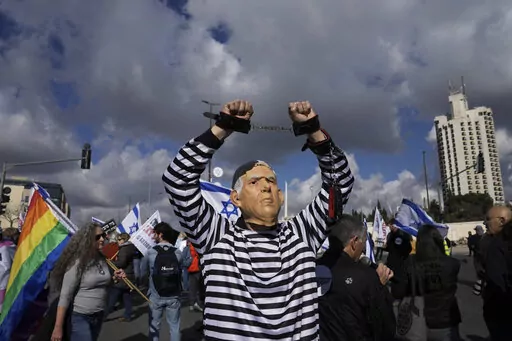 A protester wearing a rubber mask depicting Israeli Prime Minister Benjamin Netanyahu demonstrates in front of the Supreme Court in Jerusalem against the appointment of Aryeh Deri, the leader of the ultra-Orthodox Shas party as the country's new health minister, Thursday, Jan, 5, 2023. (AP Photo/Mahmoud Illean, File)