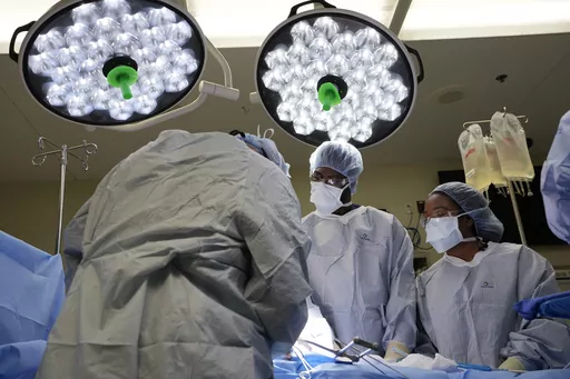Meharry Medical College students Emmanuel Kotey, center, and Teresa Belledent, right, watch as the liver and kidneys are removed from an organ donor June 15, 2023, in Jackson, Tenn. They’re part of a novel pilot program to encourage more Black and other minority doctors-to-be to get involved in the transplant field, increasing the trust of patients of color. (AP Photo/Mark Humphrey)