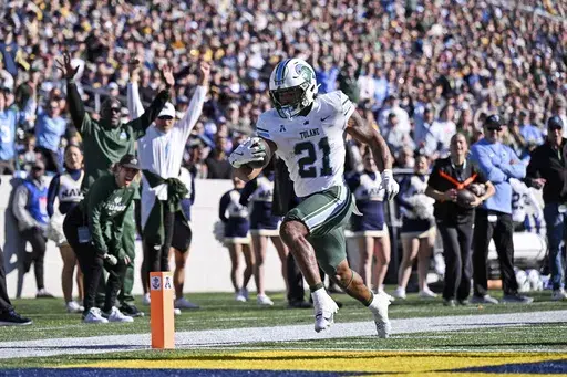 Tulane running back Makhi Hughes (21) runs the ball for a touchdown during the first half of an NCAA college football game against Navy, Saturday, Nov. 16, 2024, in Annapolis, Md. (AP Photo/Terrance Williams)
