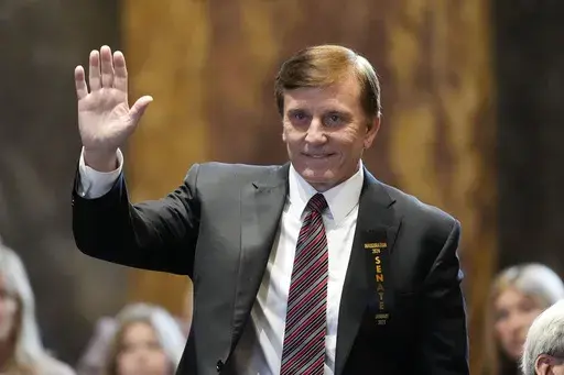 Louisiana State Treasurer John Fleming, waves as he is introduced during the swearing in of the Louisiana state legislature in Baton Rouge, La., Monday, Jan. 8, 2024. (AP Photo/Gerald Herbert, Pool, File)