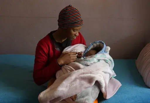 Mapule Radebe holds her baby Minehle at Nkosi's Haven, a home that assists women with HIV, in Johannesburg, Monday, Aug. 5, 2024. (AP Photo/Denis Farrell)