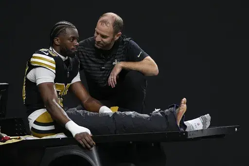 New Orleans Saints cornerback Paulson Adebo (29) is carted off the field after getting injured during the first half of an NFL football game against the Denver Broncos, Thursday, Oct. 17, 2024, in New Orleans. (AP Photo/Gerald Herbert)